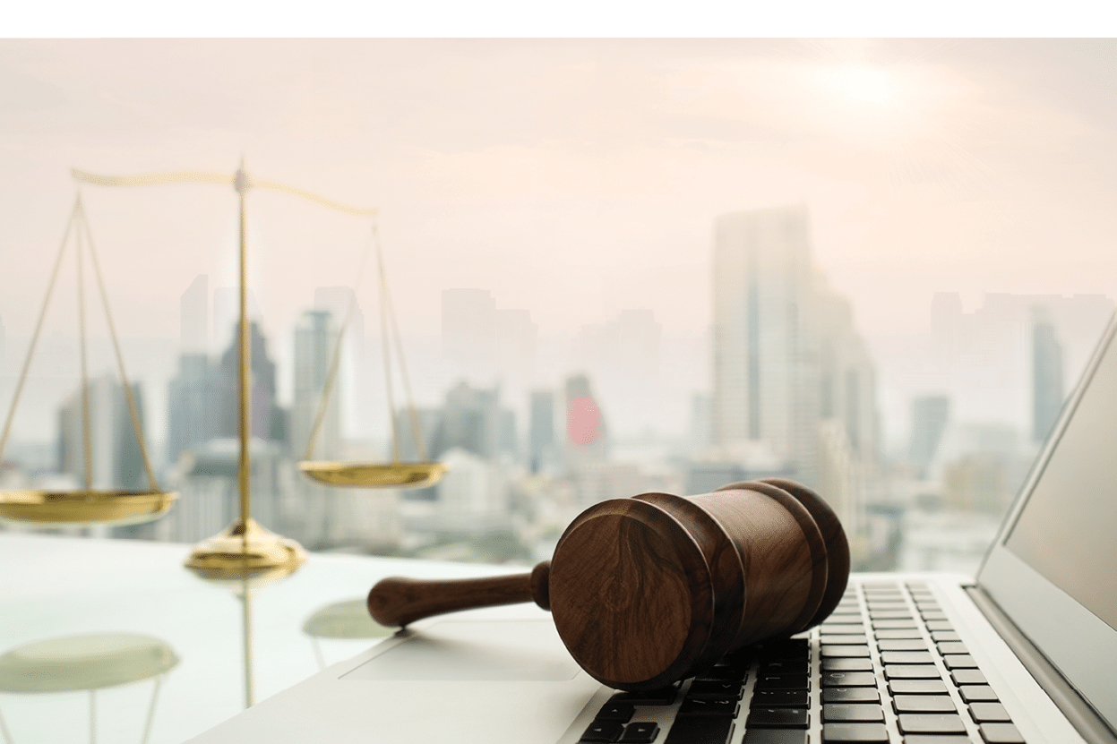 law legal technology concept. judge gavel on computer with scales of justice on desk of lawyer.