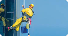 Worker Cleaning a Facade of One of the Buildings in Downtown Abu Dhabi. Abu Dhabi - UAE. 19 December 2018