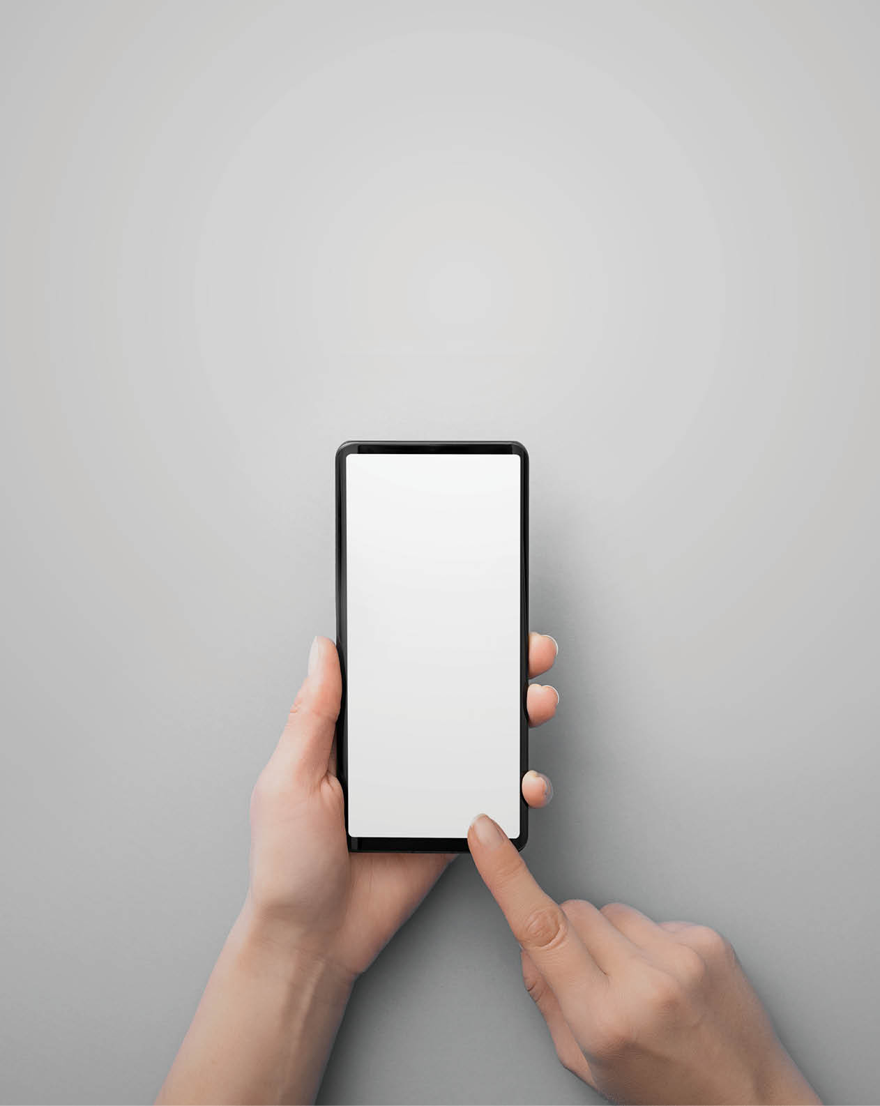 Hand holding black phone isolated on grey background and clipping path inside. Smartphone mock up concept.