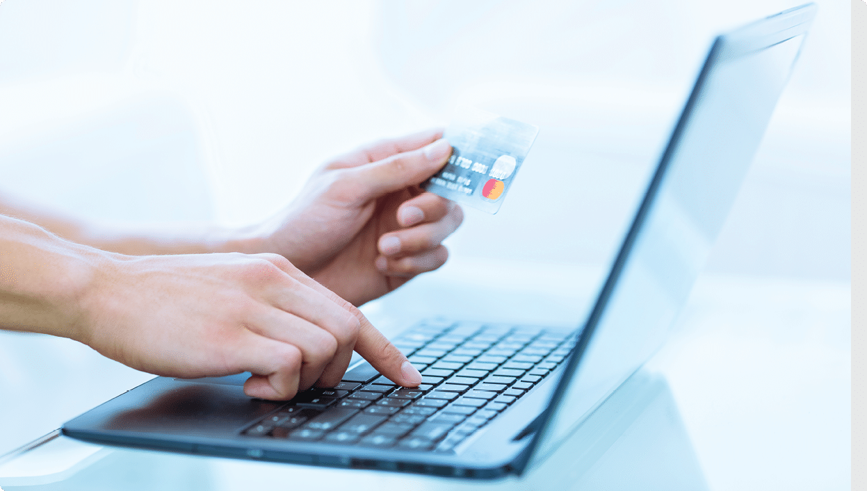 Close-up of hands shopping/paying online using laptop and credit card.