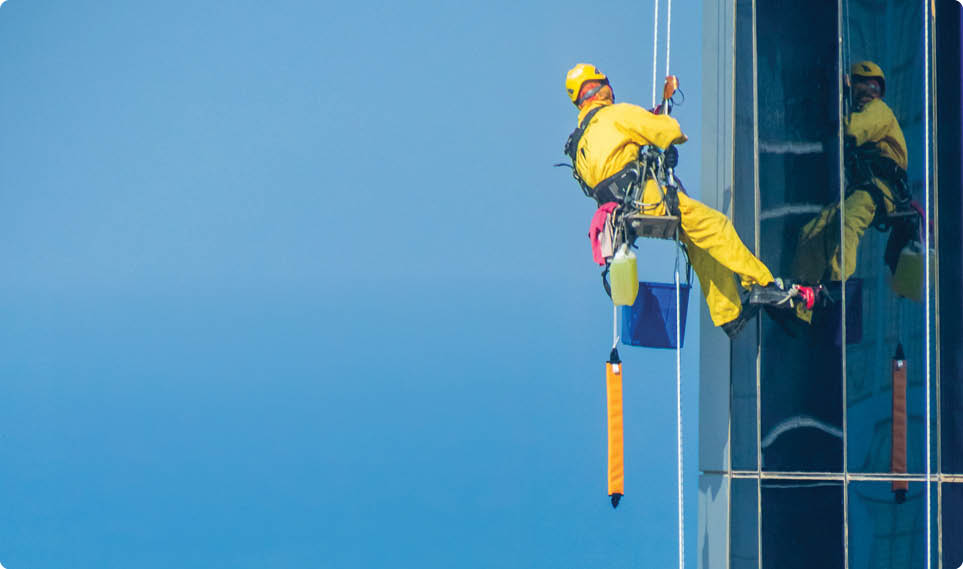 Worker Cleaning a Facade of One of the Buildings in Downtown Abu Dhabi. Abu Dhabi - UAE. 19 December 2018